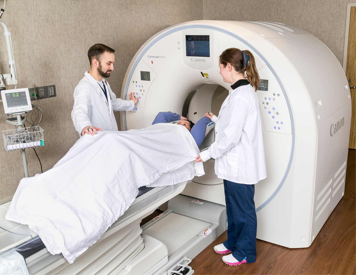 Nuclear medicine tech/CT tech Madison Eades, right, and Trey Koonce, nuclear medicine tech, work with a patient in the new Cartesion Prime PET/CT scanner.
